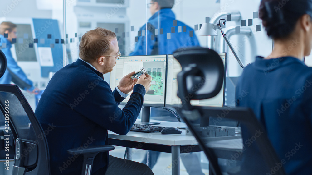 Aufkleber electronics factory: male electrical engineer holds pcb prototype, works on computer, uses cad softw