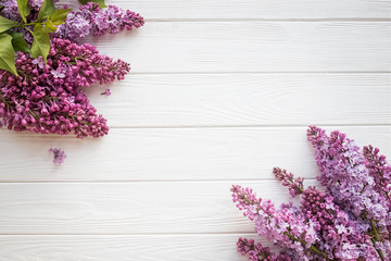 The beautiful lilac flowers on a white wooden background