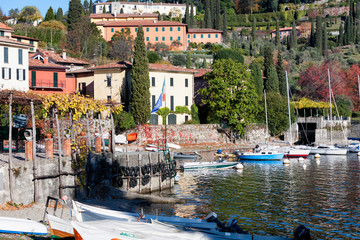 Bellagio, Como. Spiaggia di sassi con barche in autunno