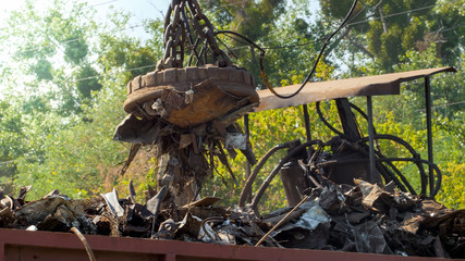 Image of metal scrap and waste stcking to the electric magnet on dump