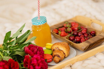 breakfast in bed with coffee, croissants, strawberries and juice