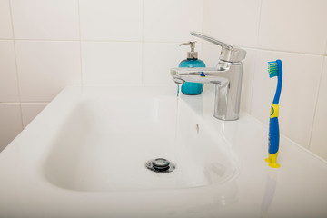 Interior of bathroom with sink basin faucet and blue soap. Design of bathroom
