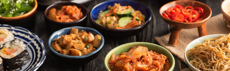 horizontal crop of tasty korean dishes on wooden surface