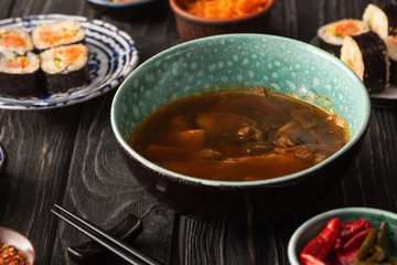 selective focus of ramen near korean kimbap and chili peppers