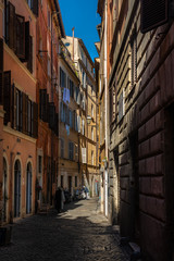 Fototapeta na wymiar Klimatyczna uliczka w sercu Rzymu, piękna gra światła i cienia.