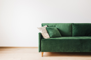 modern green sofa with pillows in spacious room