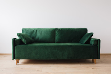 modern green sofa with pillows in room
