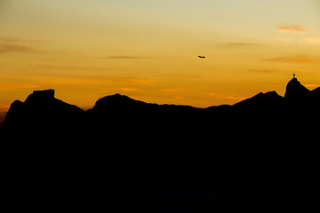 airplane flying over the mountains of Rio de Janeiro, Pedra da Gávea and Pedra Bonita, corcovado hill in a beautiful sunset.