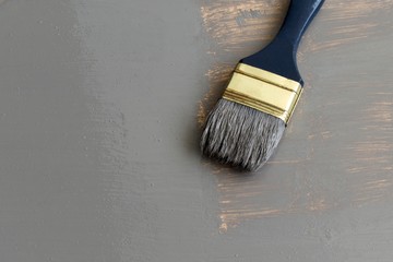 paint brush on a wooden surface, painted panel from top view