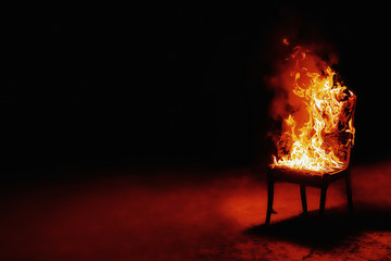 Burning chair on a black background. Conceptual photo burnout at work. Place for an inscription.