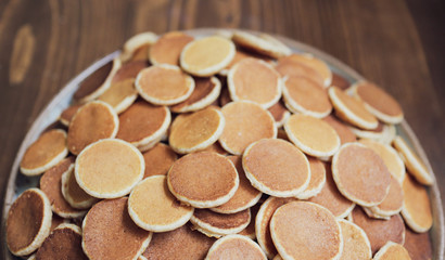 Freshly baked a plate of poffertjes, traditional Dutch Mini Pancakes without any other ingredients with the wooden background
