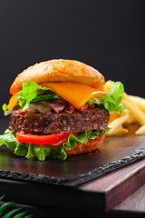 Beef burger with french fries, beef cutlet, cheese, vegetables