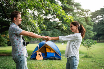Picnic and Camping time. Young couple having fun in the moment of love in the park. Love and tenderness, Romantic man playing guitar to his girlfriend, lifestyle concept