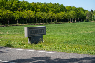 Vintage road sign welcoming you into the small prison town of Veenhuizen in Drenthe, the Netherlands.