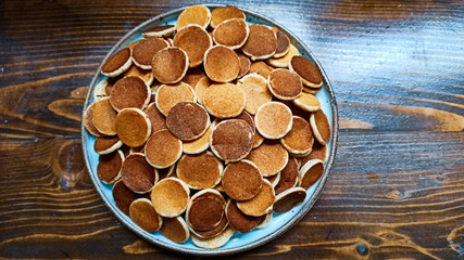 Freshly baked a plate of poffertjes, traditional Dutch Mini Pancakes without any other ingredients with the wooden background