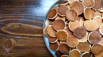 Freshly baked a plate of poffertjes, traditional Dutch Mini Pancakes without any other ingredients with the wooden background