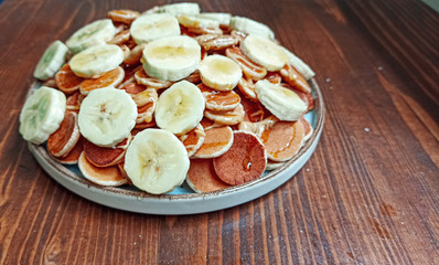 A plate of poffertjes, traditional Dutch Mini Pancakes served with honey, peanut butter and banana on the wooden background