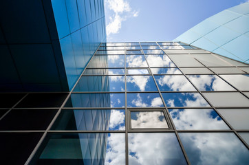 reflection of blue sky with clouds in an office building window