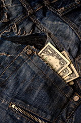 American dollars in a ripped jeans pocket.
