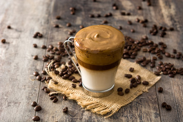 Creamy iced dalgona coffee on wooden table. 	