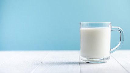 Banner of a glass of milk on a blue background. The concept of farm dairy products, the use of milk. Copy space.