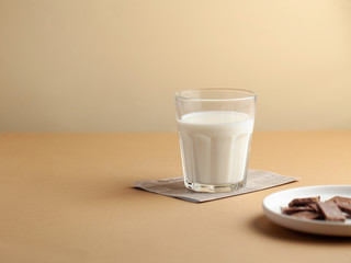 Glass of milk, chocolate on a white plate. The concept of farm dairy products, the use of milk. Copy space.