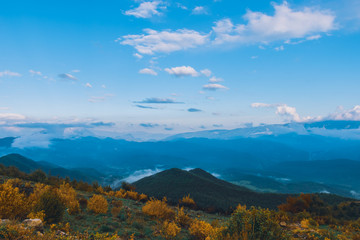 A picturesque wide landscape view of the French Alps mountains covered in clouds in the evening (Col de Rigaudon, Alpes-Maritimes, France)