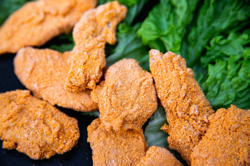 Raw Chicken nuggets on dark background