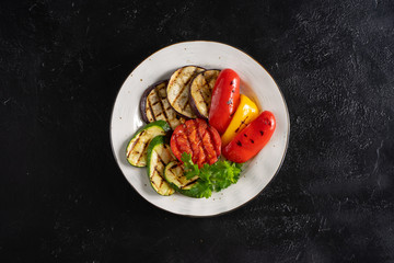 Grilled vegetables with parsley. Grilled eggplant, tomato, red and yellow bell peppers and zucchini.