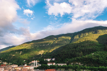 Fototapeta premium A picturesque wide view of a medieval French village in the low Alps mountain valley in the early evening (Puget-Theniers, Alpes-Maritimes, France)