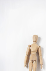 Conceptual image of a wooden man on a wall background.