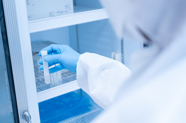 Close up scientist hand opening storage reagent container.Scientist hand holding reagent tube...