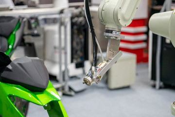 The painting robot spray the green color to the motorcycle mask parts. The automatic automotive...