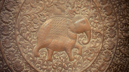 A close up of engraved elephant on wood