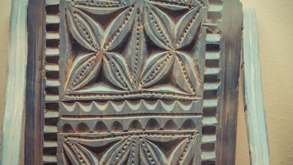 A close up of engraved wood on wall