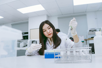 young female scientist use auto pipette to transfer sample in medical laboratory.