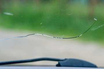 .close-up photo of a cracked windscreen, view from inside of the car