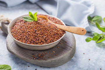 Raw  red  quinoa seeds (lat. Chenopodium quinoa) on  plate with wooden spoon
