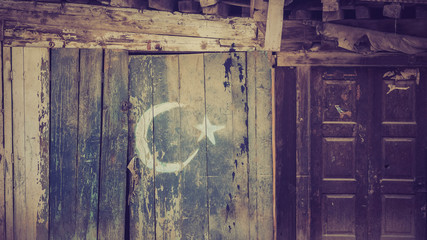 A wooden door with cresent and star symbol