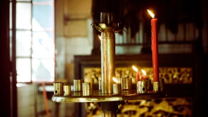 Burning red candles on the gold holder