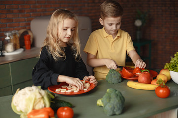 Brother and sister. Children prepare the salad. Kids in the kitchen.