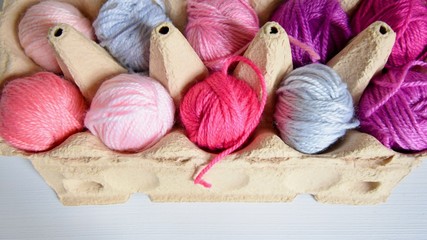 great and pink balls of wool in an egg carton 
