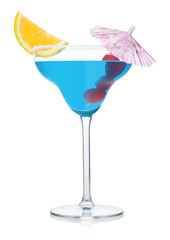 Blue lagoon cocktail in margarita glass with orange slice and sweet cherry with umbrella on white.