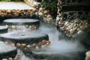 Defocused and blurred image for background. Hot Springs, Boiling and steaming water in geyser vent. Steaming geothermal hot water, Large stones arranged, Boiling water splash. closeup, vintage style.