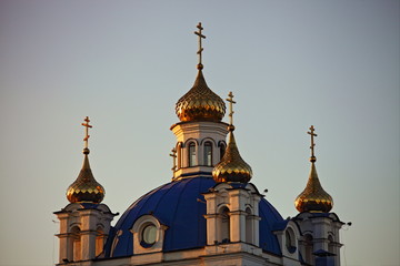 Fototapeta na wymiar Beautiful Golden domes with crosses close up on Chtistianity Church blue roof on Sunny sunset, symbol of faith