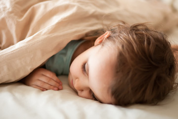 Little cute girl sleeping in a bed in her bedroom