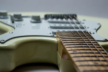 Fototapeta premium White electric guitar on a white background. In the photo, the neck and guitar deck