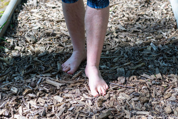  Close-up top view image.A man walking barefoot in the park.Barefoot path with wood chips.healthcare concept.