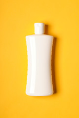 White bottle over yellow background