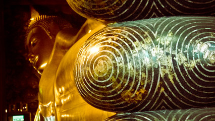 Swirling crafted metal stone beside gold Buddha